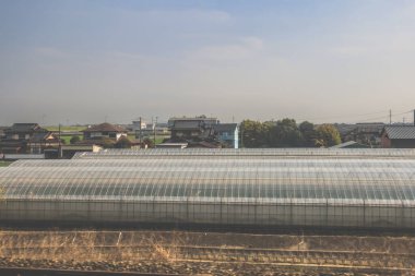 28 Mart 2025 'te geniş modern sera ile geleneksel evlerin sakin manzarası