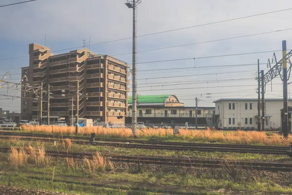 28 Mart 2025 'te tren raylarının yanında bir apartman dairesi görünüyor.