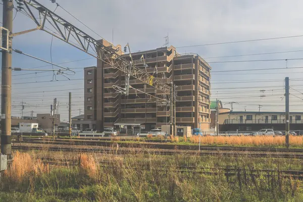 28 Mart 2025 'te tren raylarının yanında bir apartman dairesi görünüyor.