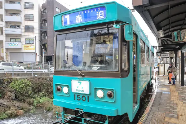 28 Mart 2025 Bir turkuaz şehir tramvayı küçük bir istasyonda duruyor.