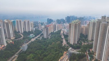 Yoğun yüksek binaları, dolambaçlı yolları, yeşilliği olan canlı bir şehir.