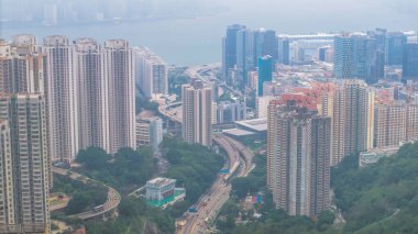 Yoğun yüksek binaları, dolambaçlı yolları, yeşilliği olan canlı bir şehir.