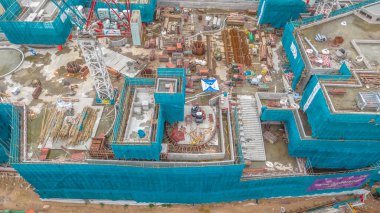 Yapı iskelesi ve ekipman içeren bir inşaat alanının yüksek açılı görüntüsü,