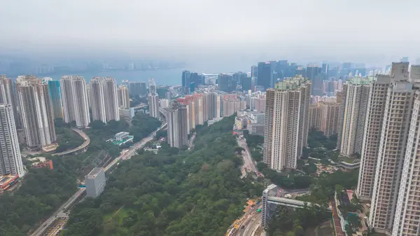Yoğun yüksek binaları, dolambaçlı yolları, yeşilliği olan canlı bir şehir.
