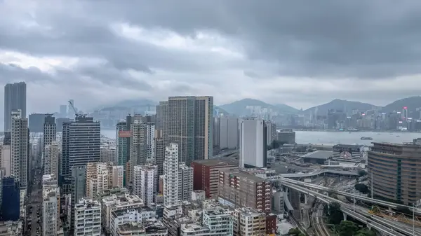 Etrafı yollarla çevrili yüksek bir konut binasının bulunduğu canlı şehir manzarası,