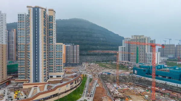 Vinçlerle çevrili yüksek katlı bir apartman.