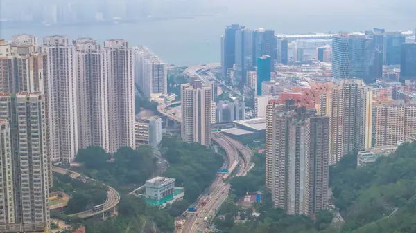 Yoğun yüksek binaları, dolambaçlı yolları, yeşilliği olan canlı bir şehir.