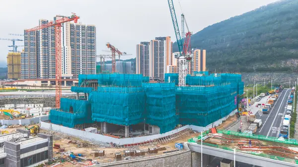 Yapı iskelesi ve ekipman içeren bir inşaat alanının yüksek açılı görüntüsü,