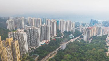 Yoğun yüksek binaları, dolambaçlı yolları, yeşilliği olan canlı bir şehir.