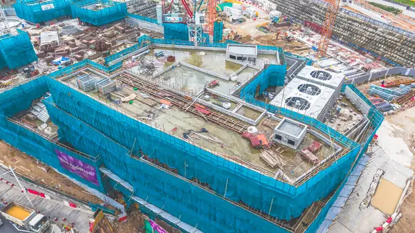 Yapı iskelesi ve ekipman içeren bir inşaat alanının yüksek açılı görüntüsü,