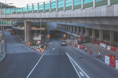 Ses bariyerleriyle çevrili ve yüksek binalarla çevrili kıvrımlı bir şehir yolu.