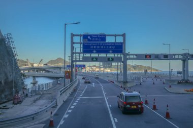 Temiz asfalt şeritli ve yeşil yapraklı yüksek bir yol.