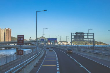 Temiz asfalt şeritli ve yeşil yapraklı yüksek bir yol.