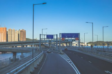 Temiz asfalt şeritli ve yeşil yapraklı yüksek bir yol.