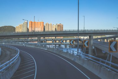 Temiz asfalt şeritli ve yeşil yapraklı yüksek bir yol.