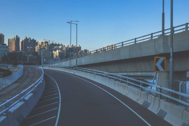 Temiz asfalt şeritli ve yeşil yapraklı yüksek bir yol.