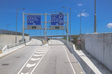 Temiz asfalt şeritli ve yeşil yapraklı yüksek bir yol.