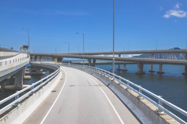 Temiz asfalt şeritli ve yeşil yapraklı yüksek bir yol.