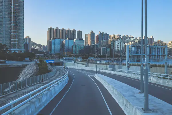 Temiz asfalt şeritli ve yeşil yapraklı yüksek bir yol.