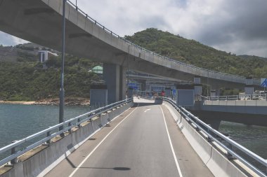 Temiz asfalt şeritli ve yeşil yapraklı yüksek bir yol.