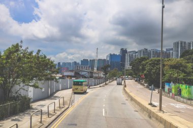 Kavisli bir karayolu, araçlar ve manzaralı bir şehir silueti içeren şehir yolu.