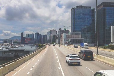 Şehir trafiği modern gökdelenlerle dolu yoğun bir otoyol boyunca akıyor.