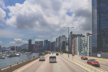 Şehir trafiği modern gökdelenlerle dolu yoğun bir otoyol boyunca akıyor.