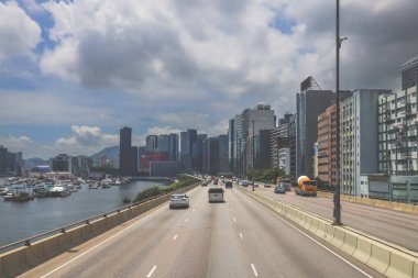Şehir trafiği modern gökdelenlerle dolu yoğun bir otoyol boyunca akıyor.