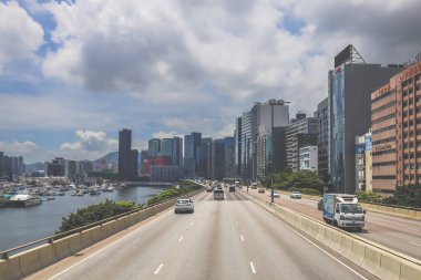 Şehir trafiği modern gökdelenlerle dolu yoğun bir otoyol boyunca akıyor.