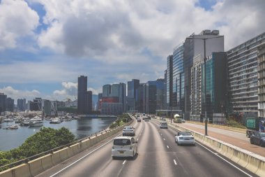 Şehir trafiği modern gökdelenlerle dolu yoğun bir otoyol boyunca akıyor.