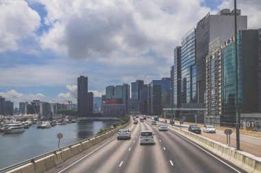 Şehir trafiği modern gökdelenlerle dolu yoğun bir otoyol boyunca akıyor.