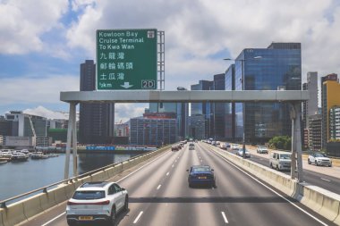 Şehir trafiği modern gökdelenlerle dolu yoğun bir otoyol boyunca akıyor.