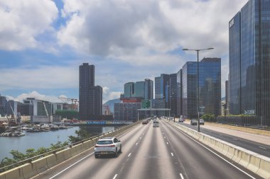 Şehir trafiği modern gökdelenlerle dolu yoğun bir otoyol boyunca akıyor.