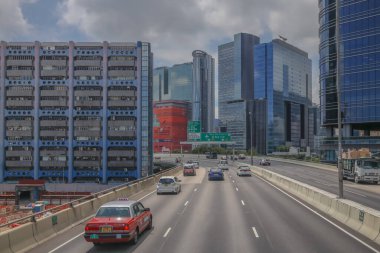 Modern gökdelenlerin ve benzersiz gökdelenlerin kuşattığı bir şehir otoyolu manzarası