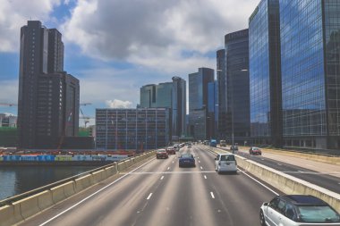Modern gökdelenlerin ve benzersiz gökdelenlerin kuşattığı bir şehir otoyolu manzarası
