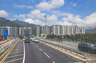 Şehir kavşağı trafiği, şehir silüeti ve güneşli bir havanın altındaki dağlar