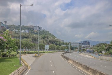 Şehir yolu kıvrımları yemyeşil ve konut tepe binalarının yanında.