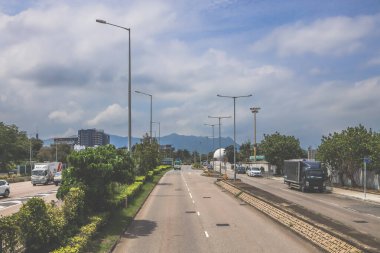 Şehir yolu kıvrımları yemyeşil ve konut tepe binalarının yanında.