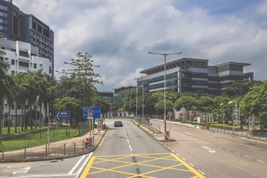 Yüksek binalarla çevrili sakin bir şehir yolu.