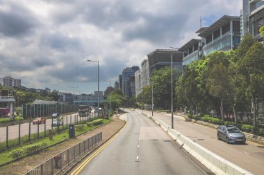 Yüksek binalarla çevrili sakin bir şehir yolu.
