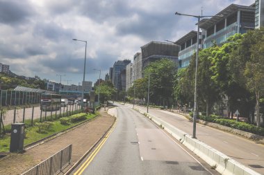 Yüksek binalarla çevrili sakin bir şehir yolu.