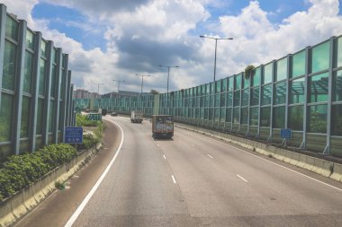 Modern bir otoyolda bulutlu gökyüzünün altında seyahat eden arabalar vardır.,