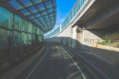 Çağdaş üstgeçit yapılarıyla çevrili kıvrımlı kentsel yol camlı.