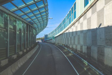 Çağdaş üstgeçit yapılarıyla çevrili kıvrımlı kentsel yol camlı.