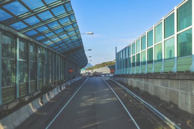 Çağdaş üstgeçit yapılarıyla çevrili kıvrımlı kentsel yol camlı.