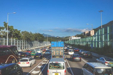 açık mavi gökyüzünün altındaki ağaçların ve binaların arka planı. Canlı bir şehirde güneşli bir günde, şehir içi gidip gelen yaşam tarzını yakalar..