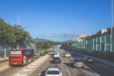 açık mavi gökyüzünün altındaki ağaçların ve binaların arka planı. Canlı bir şehirde güneşli bir günde, şehir içi gidip gelen yaşam tarzını yakalar..