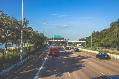 açık mavi gökyüzünün altındaki ağaçların ve binaların arka planı. Canlı bir şehirde güneşli bir günde, şehir içi gidip gelen yaşam tarzını yakalar..