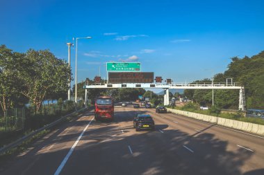 açık mavi gökyüzünün altındaki ağaçların ve binaların arka planı. Canlı bir şehirde güneşli bir günde, şehir içi gidip gelen yaşam tarzını yakalar..