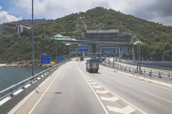 Temiz asfalt şeritli ve yeşil yapraklı yüksek bir yol.